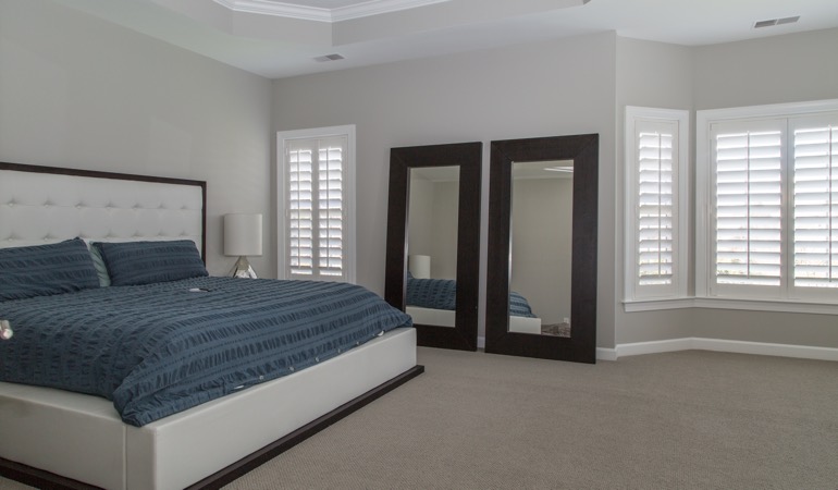 White shutters in a minimalist bedroom in New York.